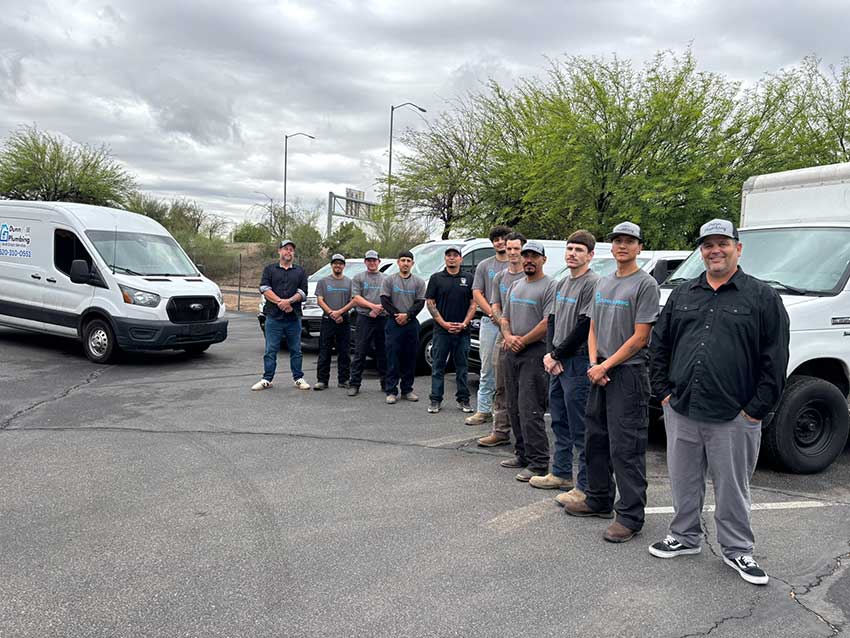 Dunn Plumbing team standing in front of service trucks in Tucson